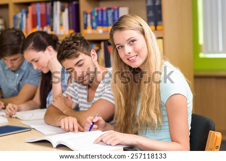 Group of college students doing homework in the library