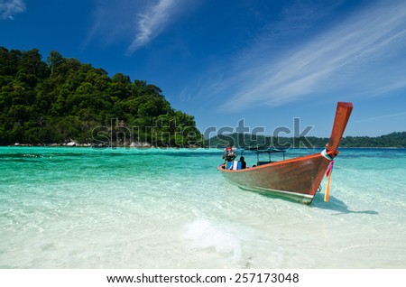 Boat waiting for tourist in clear sea and white sand beach at Lipe Island, Thailand

