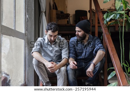 Couple of young men talking on the stairs of an office Royalty-Free Stock Photo #257195944