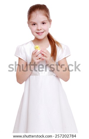 Happy charming little girl in a white dress preparing for a happy Easter