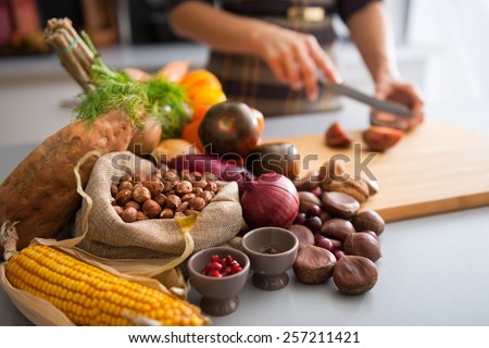 Closeup on vegetables and young housewife cutting cherokee purple tomato Royalty-Free Stock Photo #257211421