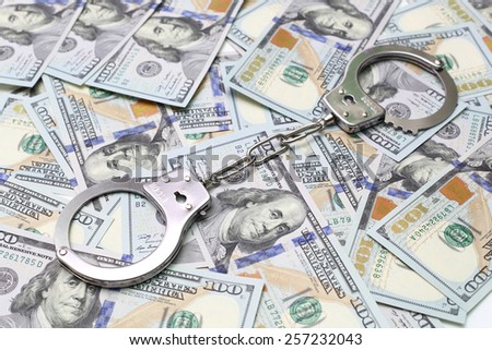 handcuffs on a pack of dollars