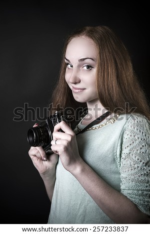 Hot photographer woman taking pictures with old camera