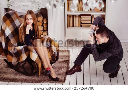 A man is taking photo of a young beautiful girl in studio.