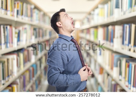 Man wearing a blue shirt and red tie. He is looking surprised. Over library background
