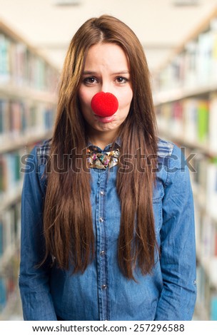 Trendy young woman with a red nose. She is looking sad. Over library background