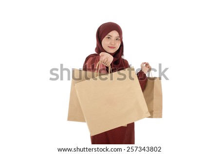 Happy young muslim woman with shopping bag isolated over white background
