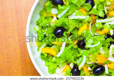 Assorted salad of green leaf lettuce with squid and black olives, close up