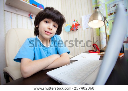 schoolboy doing homework on a laptop