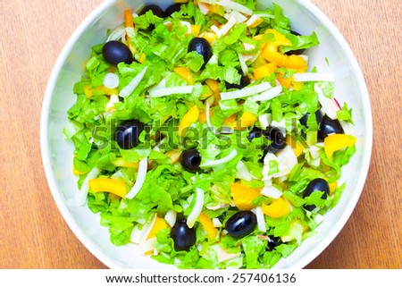 Assorted salad of green leaf lettuce with squid and black olives