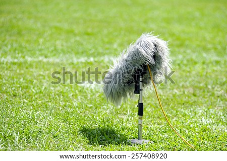  selective focus of professional sport microphone on grass during midday