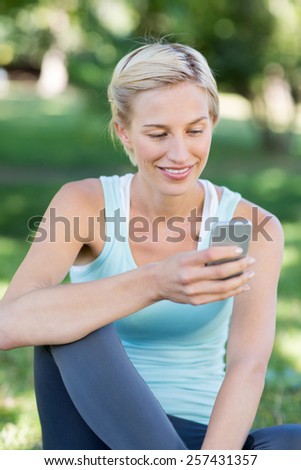 Pretty blonde using smartphone on a sunny day