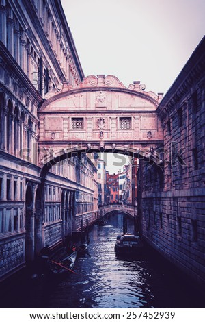 Gondolas floating on canal towards Bridge of Sighs (Ponte dei Sospiri). Venice, Italy. Perspective. Toned dark photo.