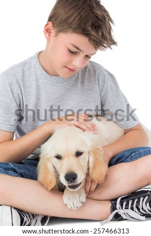 Loving boy stroking dog while sitting over white background