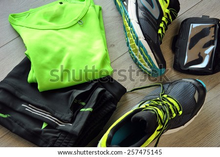 Clothes make running with isotonic drink, phone and T-shirt Royalty-Free Stock Photo #257475145