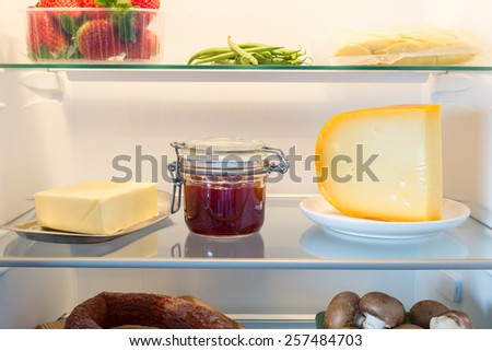 Open fridge filled with food. Royalty-Free Stock Photo #257484703