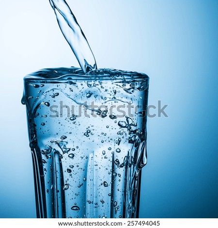 overflowing water in a glass Royalty-Free Stock Photo #257494045