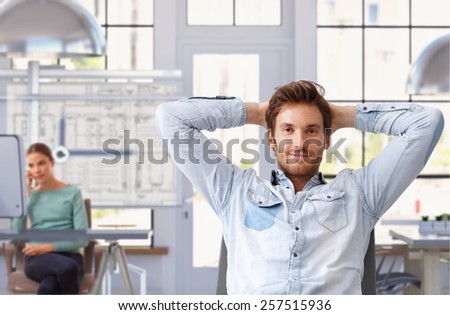 Young man taking break of work at trendy architect office Royalty-Free Stock Photo #257515936