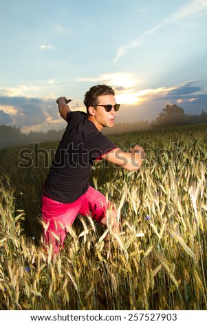 lifestyle. a man in a field at sunset enjoying life, good weather, fresh air and silence