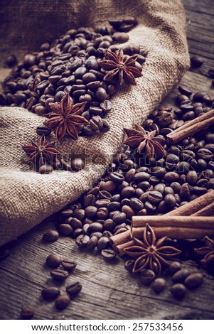 Coffee beans with cinnamon and anise on wooden background
