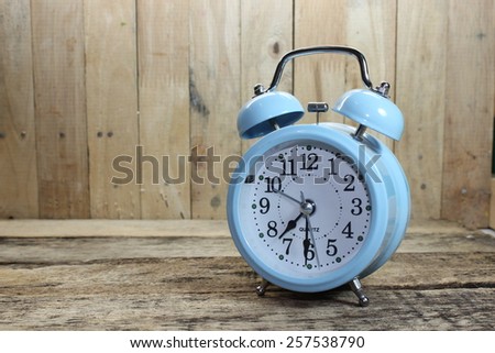 Wooden background with retro alarm clock on table