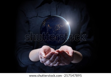 Businesswoman holding Earth planet in palm. Elements of this image are furnished by NASA