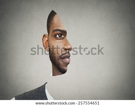Optical illusion surrealistic portrait front with cut out profile of a young man isolated on grey wall background