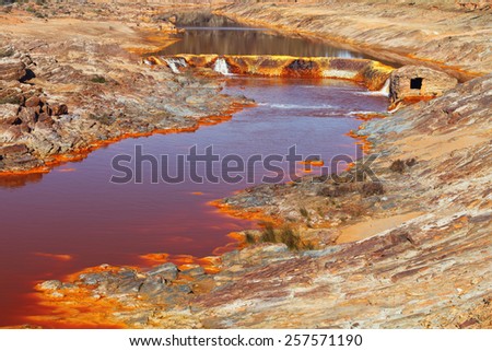 Death and desolation in the Tinto River,Spain. As a possible result of the mining, Rio Tinto is notable for being very acidic and its deep reddish hue is due to iron and copper dissolved in the water.