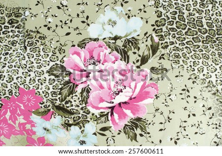 Floral and cheetah pattern on fabric. Brown leopard pattern with pink roses. Spotted animal print as background. 