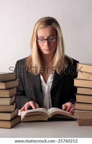 A young pretty woman reading a book and sitting on a table above a white background