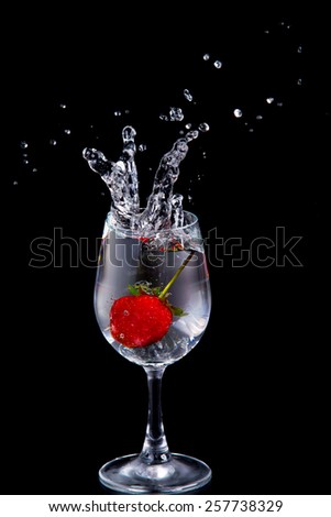Strawberry in wine glass  on a black background
