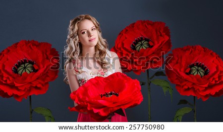 The blonde girl surrounded with red  huge poppy-flowers.