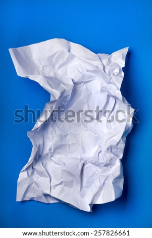 Wrinkled white piece of paper over a blue background.
