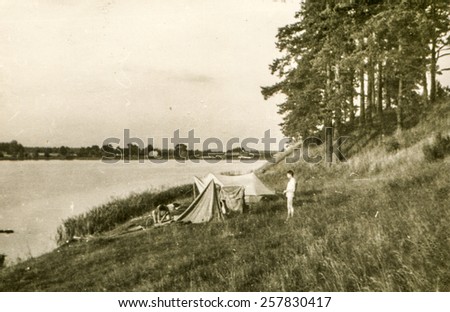 Vintage photo of young man camping during a canoe trip (1960's)