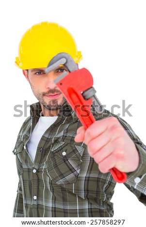 Manual worker looking through monkey wrench on white background