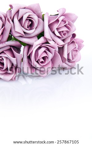artificial bouquet of purple roses on a white background