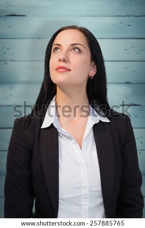 Pretty businesswoman looking up against wooden planks