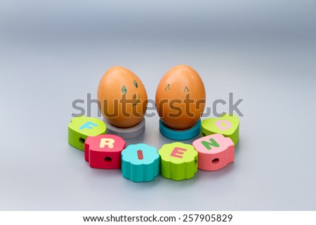 friendship concept : two eggs with friend letters on color wood