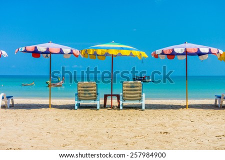 Beach umbrellas and sunbathing seats on Phuket sand beach in Southern Thailand