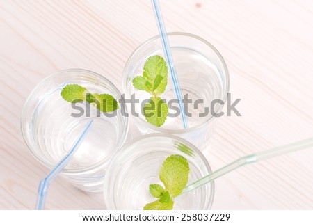 glass of clean water with mint on a table covered with  checkered napkin