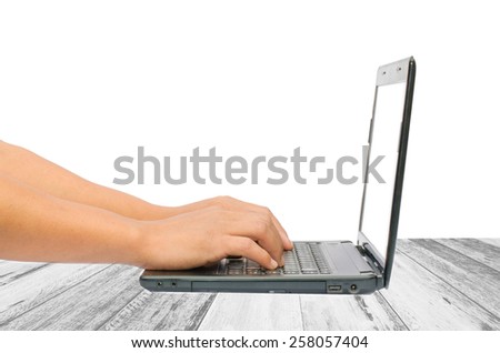 hands typing on laptop on wooden background
