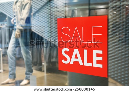 Red sign on a shop window. Sale in a clothing store