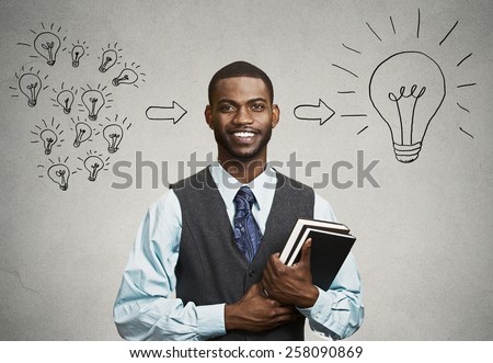 Intelligence knowledge. Closeup smart happy handsome man confident student holding books has big ideas isolated on gray wall background. Positive face expression emotion attitude life perception 