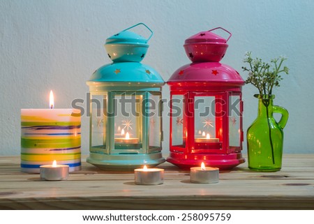 still life with candle on wooden table over grunge background, vintage style