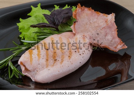 Grilled squid with rosemary on the wooden background