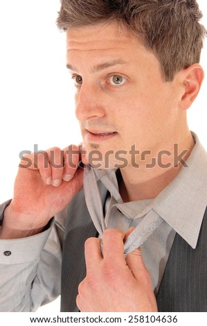 A portrait picture of a handsome young man taking of his tie, isolated on white background. 