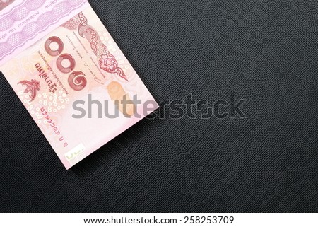 New and latest edition of Thailand one hundred baht banknotes put on the black color leather background represent the Thai financial and monetary related.