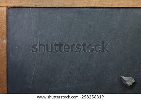 Vintage and old slate blackboard and stone put on the black color leather background represent the teaching equipment related.