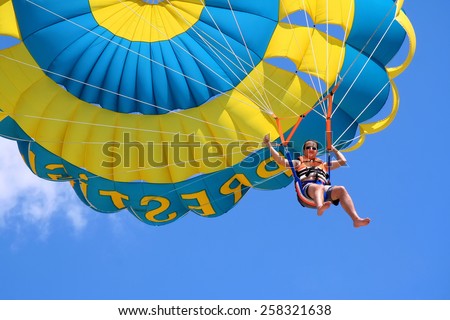 Happy man flying parasailing Royalty-Free Stock Photo #258321638