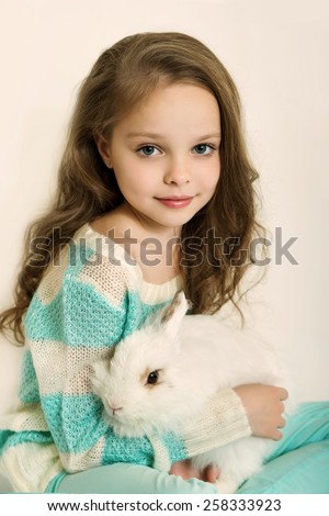 Happy little girl with rabbit. Toned photography